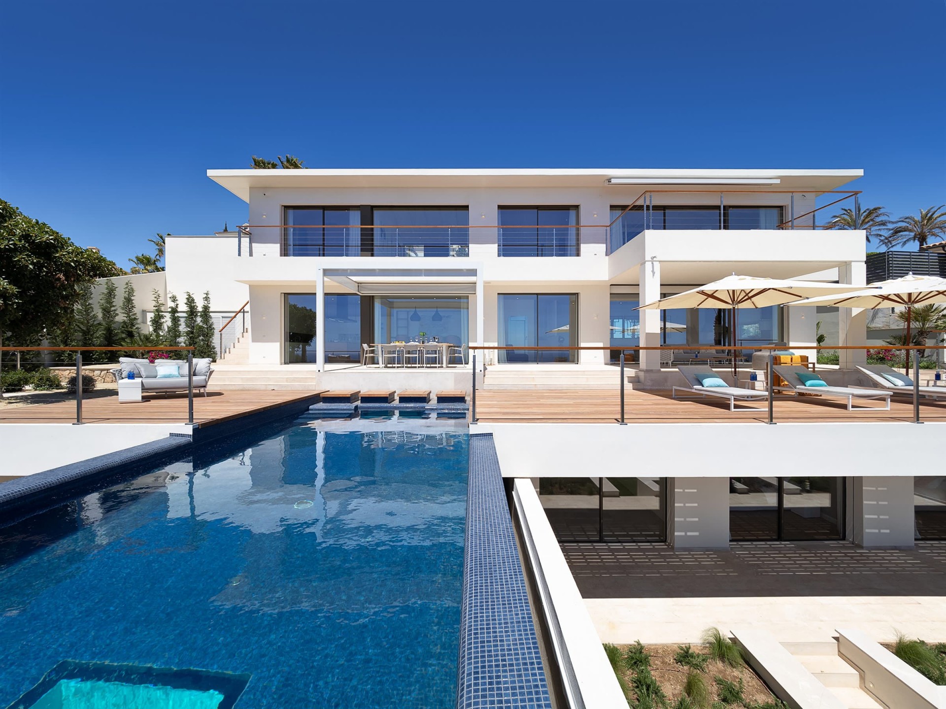 Die elegante Luxusvilla La Mansión nahe Port Adriano. Der meerblaue Infinitypool glitzert in der Sonne.