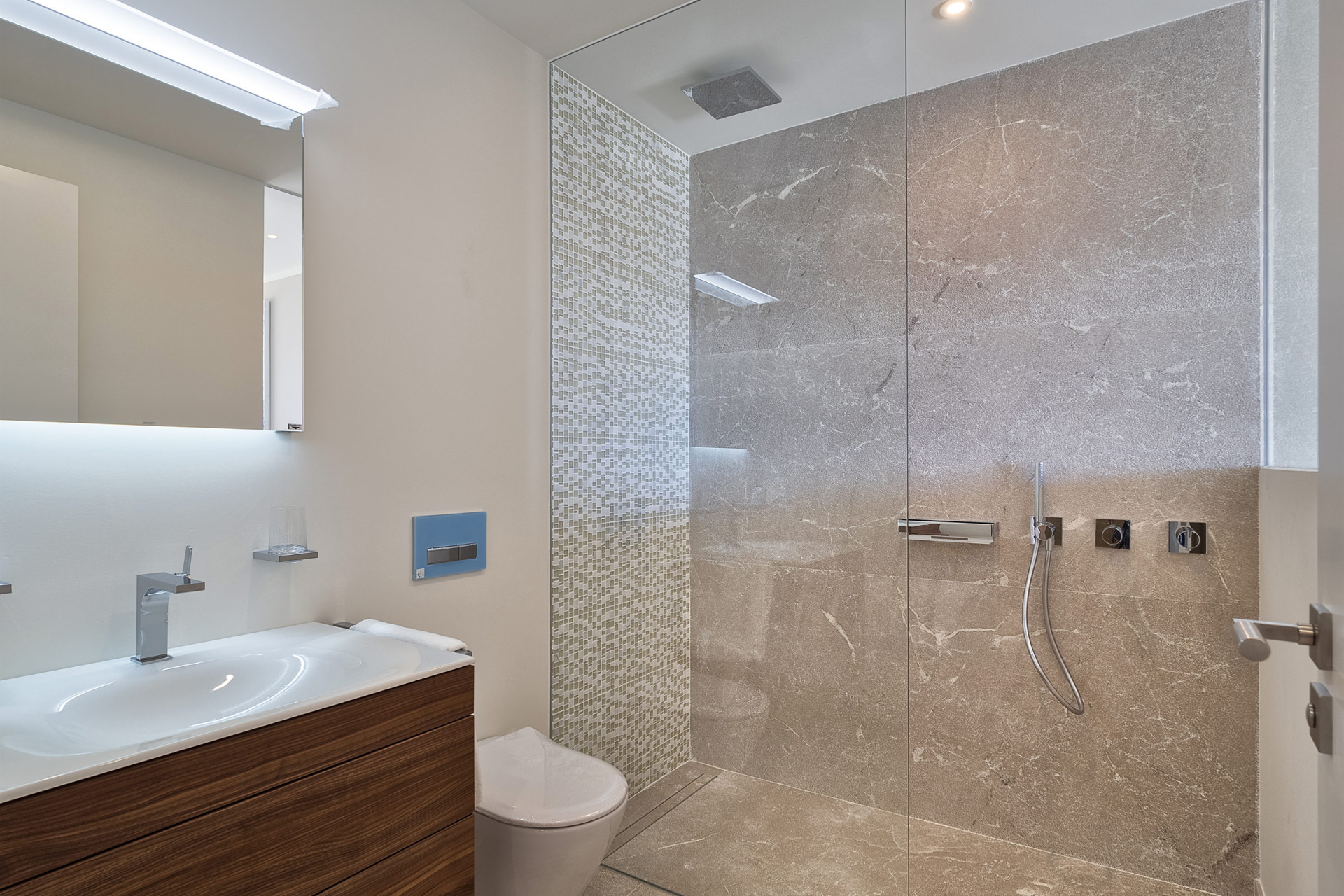 Das mit hochwertigen Marmor ausgestattete, an das beige Schlafzimmer angrenzende Duschbad.